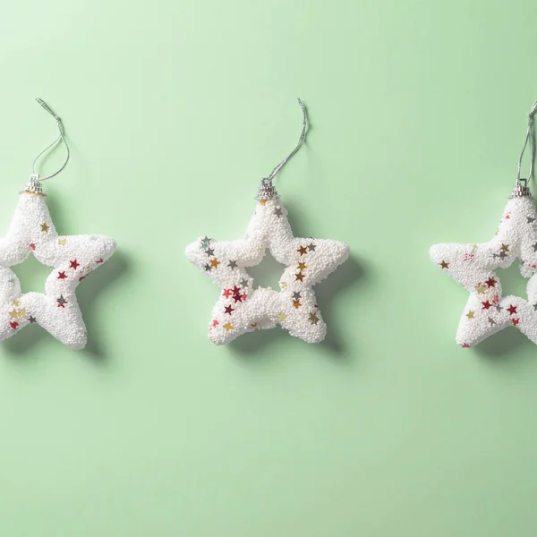 Three Bright White Christmas Stars Pastel Green Background Minimal Concept — Stock Photo, Image
