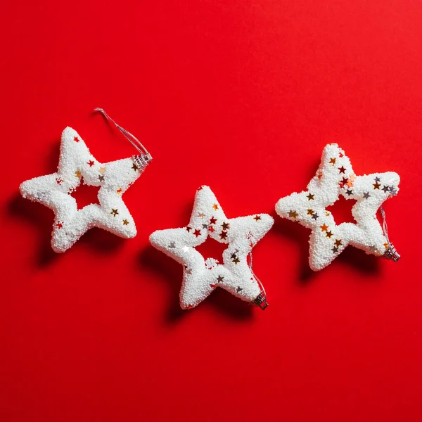 Three bright white Christmas stars on pastel background, minimal concept of Christmas and New Year. Minimalist decoration from above.