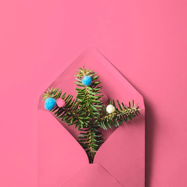Rosafarbener Umschlag Mit Tannenzweigen Und Christbaumkugeln Auf Rosa Hintergrund — Stockfoto
