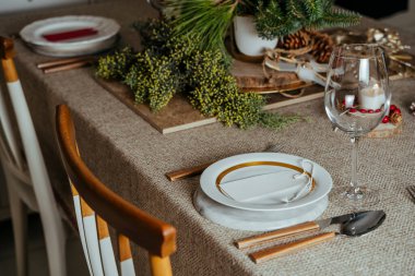 Tatil yeri dekorasyonu, boş kartlı Noel masası menüsü, süsleri ve kır bej şömine rafındaki doğal çam dalı, evde akşam yemeği.