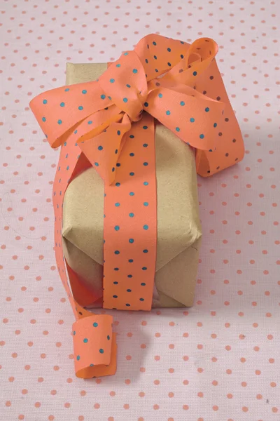 Подарочная коробка с лентой и луком, персиком и голубой точкой польки — стоковое фото