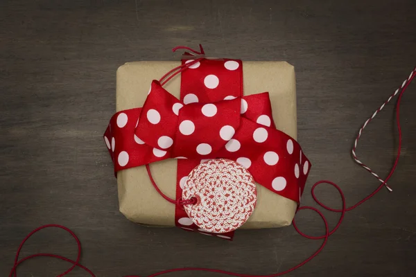 Caja de regalo hecha a mano cinta roja punteada y etiqueta , — Foto de Stock