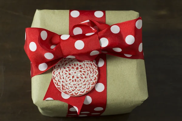 Caja de regalo hecha a mano cinta roja punteada y etiqueta , — Foto de Stock