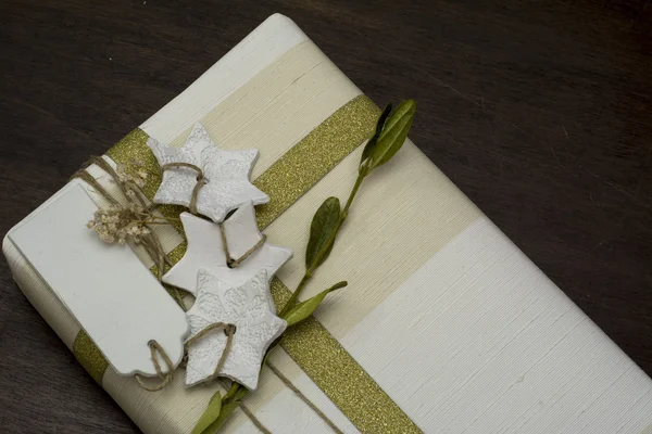 Boîte cadeau avec main, ruban d'or arc, et décoratif st blanc — Photo