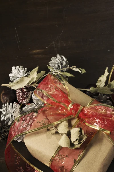 Rustikální vánoční dárek, pozadí červený robbon — Stock fotografie