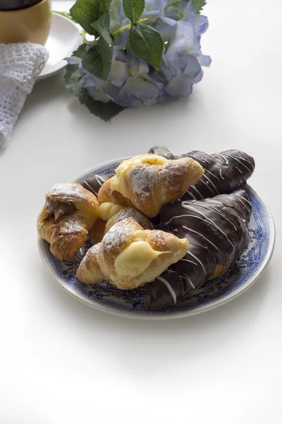 Croissant täckt med choklad och fylld med grädde och caram — Stockfoto