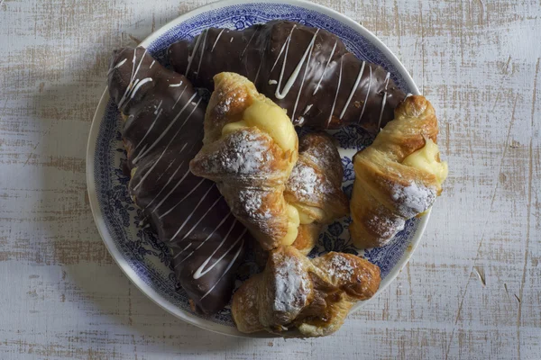 Croissant täckt med choklad och fylld med grädde och caram — Stockfoto