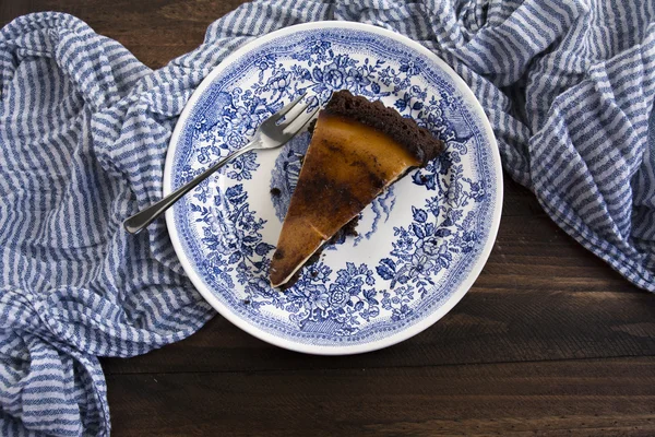 Gâteau recouvert de banane chocolat sur nappe rayée bleue — Photo