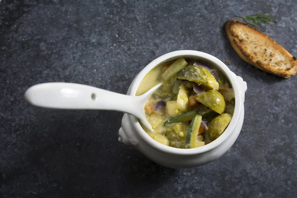 Soupe de légumes dans un bol blanc sur fond sombre avec texture — Photo