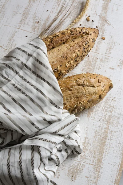 Magot kenyér rusztikus, fehér fa b csíkos szövet csomagolva — Stock Fotó