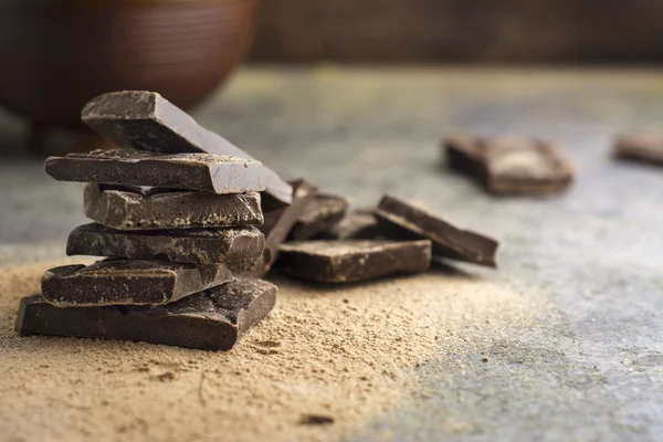 Morceaux de chocolat noir empilés sur fond grunge — Photo