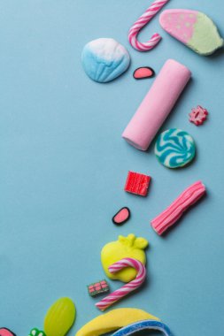 Mavi arka plan üzerinde renkli şeker karışık çocuklar tatil