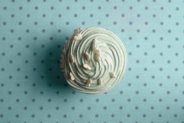Blå cupcake med vispad grädde och hjärtat strössel på prickade b — Stockfoto