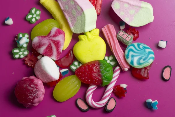 Mixed colorful candy on pink background, kids holidays — Stock Photo, Image