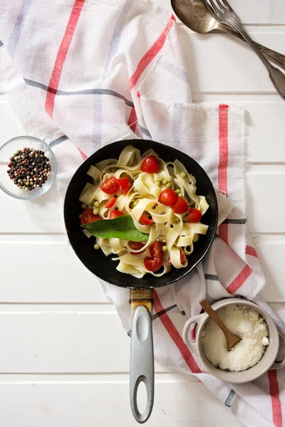 Tagliatelle Pasta with cherry tomatoes in a pan  white wooden ta — Stock Photo, Image