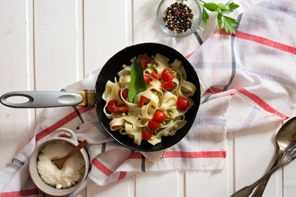 Tagliatelle Pasta with cherry tomatoes in a pan  white wooden ta — Stock Photo, Image