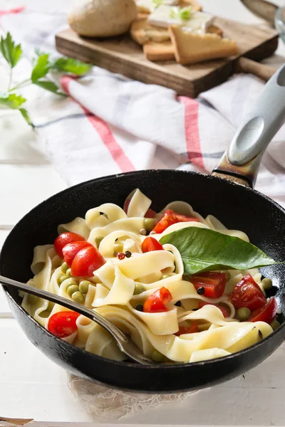 Tagliatelle Pasta with cherry tomatoes in a pan  white wooden ta — Stock Photo, Image