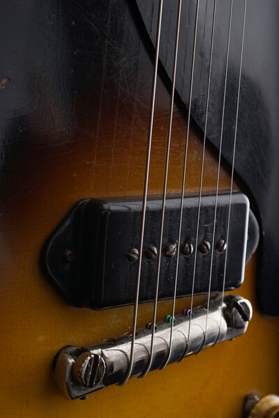 Closeup of old six-string electric guitar. Detail, selective focus.