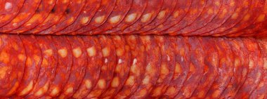 Biberli. Pepperoni sosis dilimleri. Piquant, baharatlı, dayanıklı sosisler. Tedavi edilmiş et ürünleri. Yemek arkaplanı. Kapat. Panoramik makro görüntü. yüksek çözünürlüklü pankart.