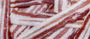 Pancetta. Dilimlenmiş İtalyan pancetta 'sı. Domuz eti salamı. Et ürünleri. Yemek arkaplanı. Kapat. Panoramik makro görüntü. Yüksek çözünürlüklü pankart.