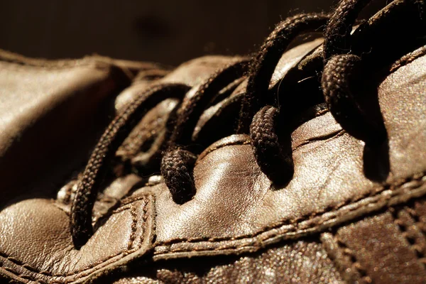 Deel van de oude schoenen met veters op houten vloer — Stockfoto