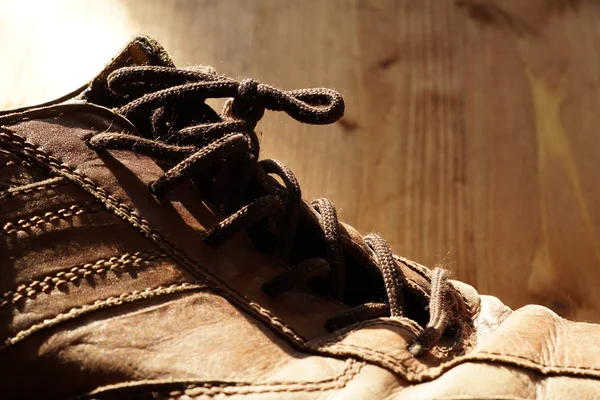 Deel van de oude schoenen met veters op houten vloer — Stockfoto