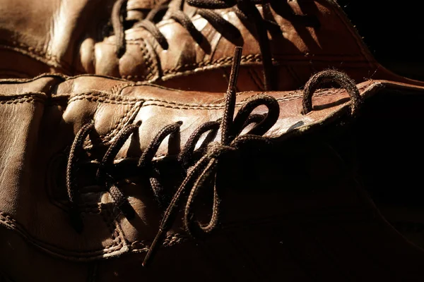 Parte de sapatos antigos com atacadores no chão de madeira — Fotografia de Stock