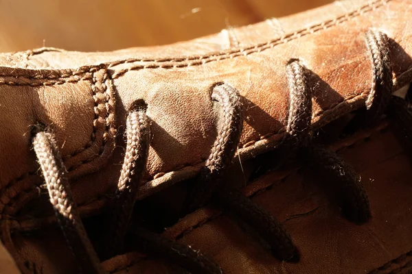 Deel van de oude schoenen met veters op houten vloer — Stockfoto