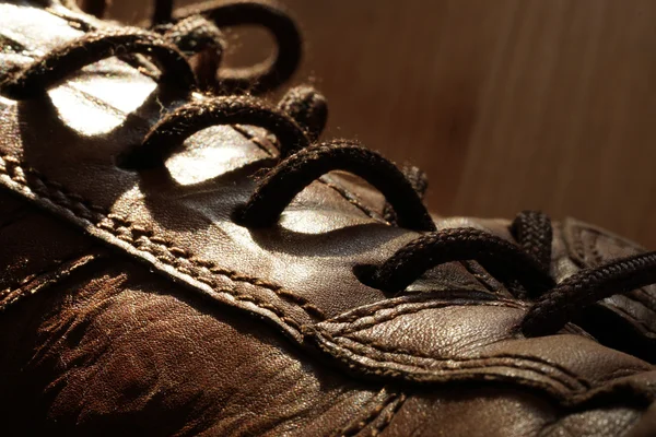 Deel van de oude schoenen met veters op houten vloer — Stockfoto