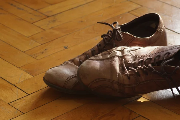 Deel van de oude schoenen met veters op houten vloer — Stockfoto