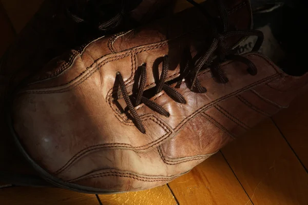 Parte de sapatos antigos com atacadores no chão de madeira — Fotografia de Stock