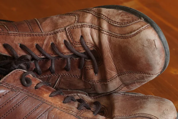 Deel van de oude schoenen met veters op houten vloer — Stockfoto