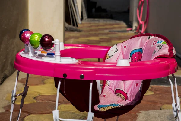 İzole edilmiş güzel pembe bebek yürüteç resmi .