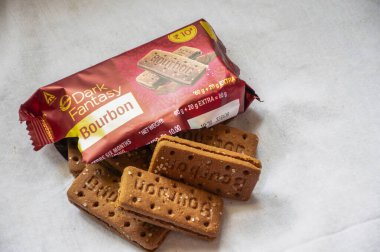 Beyaz arka planda kremalı ve çikolatalı burbon bisküvileri resmi