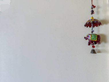 Açık sarı bir duvara asılmış el yapımı, kahverengi fil dekoratif güzel bir el yapımı fotoğraf. Fili asmaya odaklan..