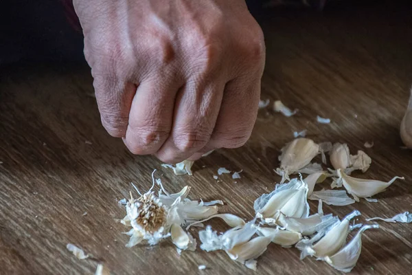 Yerlerde tutulan çiğ sarımsak soyan bir kadının stok fotoğrafı, Kolhapur Maharashtra Hindistan 'da el ele tutuşma.