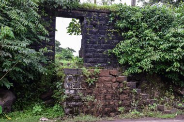 Eski çökmüş duvarın resmi. Kızılderili köyünün kara taş yol kenarından yapılmış. Yağmur mevsiminde çekilmiş bir resim. ön plana odaklan.