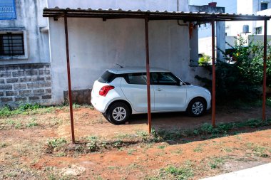 Kolhapur maharashtra Hindistan 'da, el yapımı gölgeliğin altına park edilmiş beyaz arabanın stok fotoğrafı..