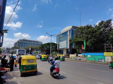 Bangalore, Hindistan _ 21 Eylül 2021; Crawdad yolundaki araçlara binen insanların, Bangalore 'daki ana yolu çevreleyen çok katlı şirket binalarında otobüs beklerken çekilmiş fotoğrafları..