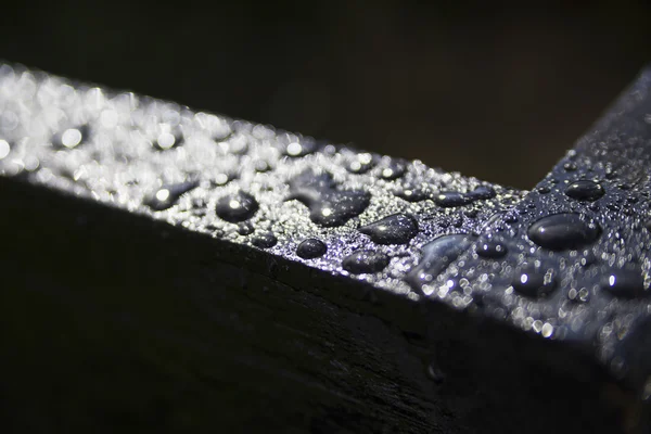 Gotas de agua sobre una superficie negra —  Fotos de Stock