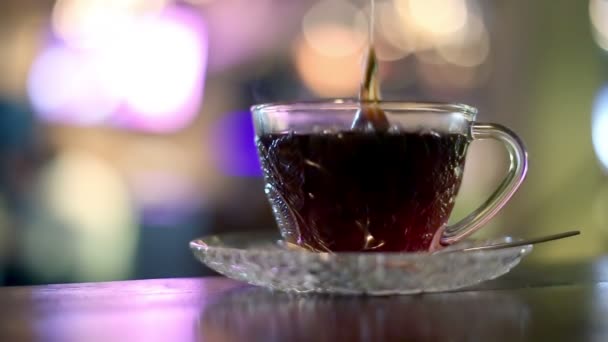 Thé noir dans un sac brassé dans une tasse en verre — Video