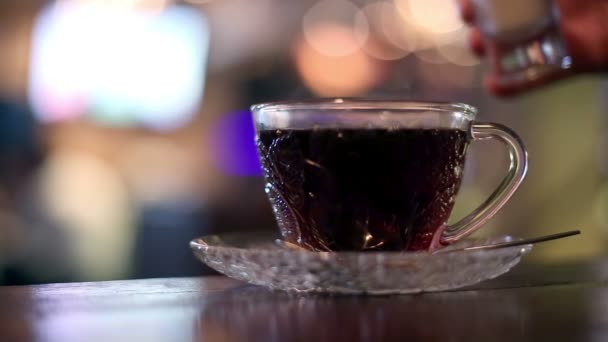 Pouring milk into hot black tea in cafe — Stock Video