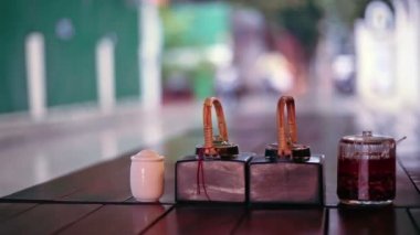 Tablo soslar ve açık Restoran, Phnom Penh, Kamboçya'dan yağışlı sokak görünümü