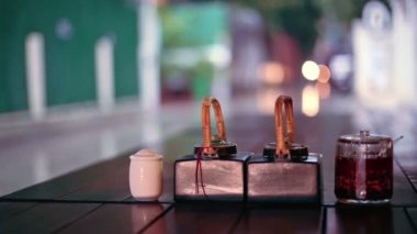 Tablo soslar ve açık Restoran, Phnom Penh, Kamboçya'dan yağışlı sokak görünümü