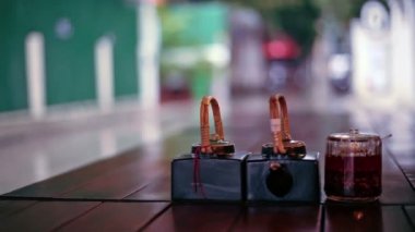 Tablo soslar ve açık Restoran, Phnom Penh, Kamboçya'dan yağışlı sokak görünümü