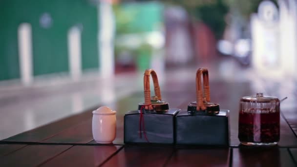 Salsas de mesa y vistas a la calle de lluvia desde el restaurante al aire libre, Phnom Penh, Camboya — Vídeos de Stock