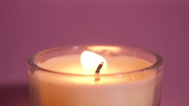 Brennende Kerzen Nahaufnahme Auf Rosa Hintergrund Zeitlupenvideo Der Kerzenflamme Aus — Stockvideo