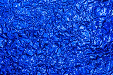 Parlak mavi folyo arka plan, dokunun arka planı için parlak buruşuk yüzey. Yanardöner yüzey kırışık folyo.