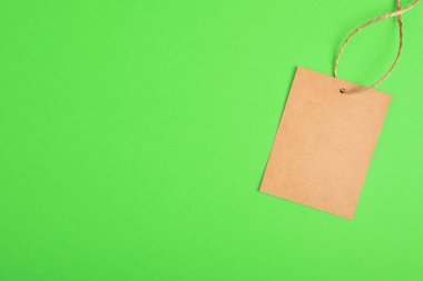 Yeşil arkaplanda el yapımı kahverengi kağıt etiketi var. Asgari stil kopya alanı olan indirimli fiyat afişi