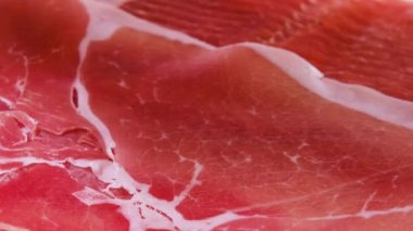 Jamon ya da kurutulmuş jambon İspanya dokusunda üretilir. Yemek arkaplanı. Eldivenin içinde ince bir dilim jamon al..
